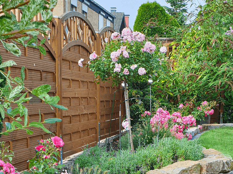 Hölzerner Sichtschutz in einem Garten mit Bepflanzung